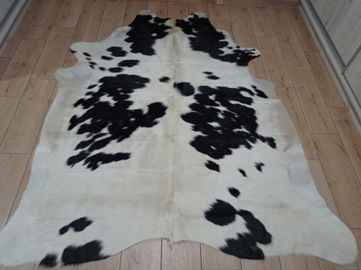 Czarno-kremowa skóra bydlęca łaciata rozłożona na jasnej podłodze - dekoracyjneskory.pl