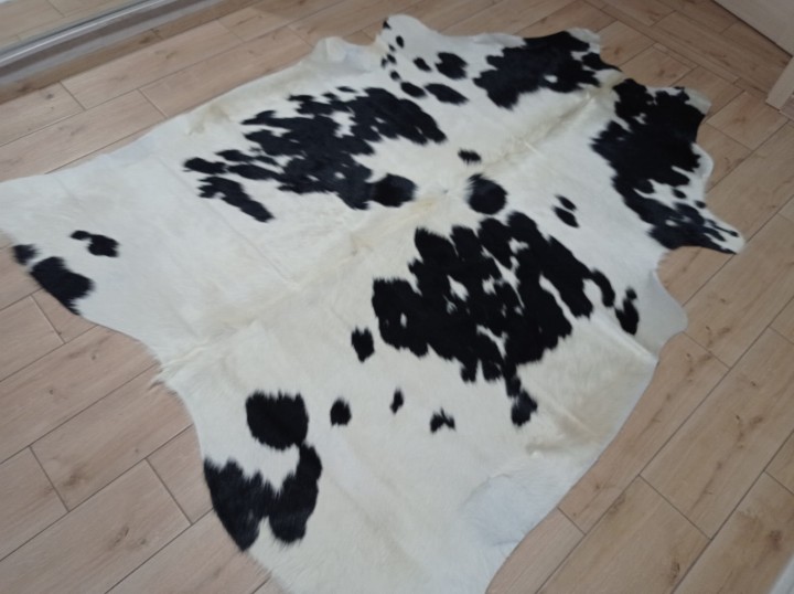 Czarno-kremowa skóra bydlęca łaciata rozłożona na jasnej podłodze - dekoracyjneskory.pl