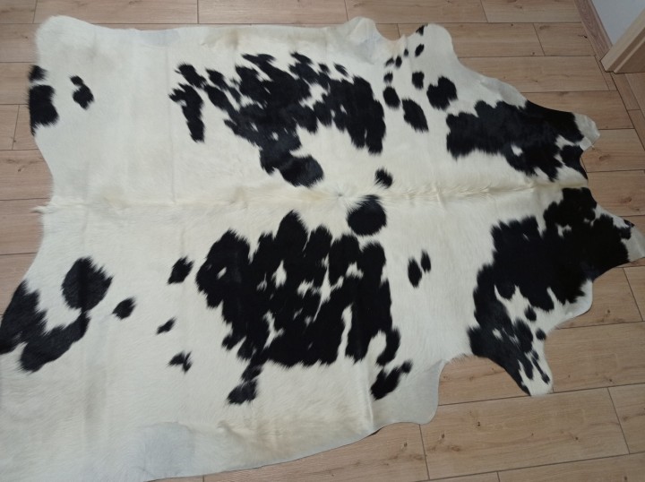 Czarno-kremowa skóra bydlęca łaciata rozłożona na jasnej podłodze - dekoracyjneskory.pl