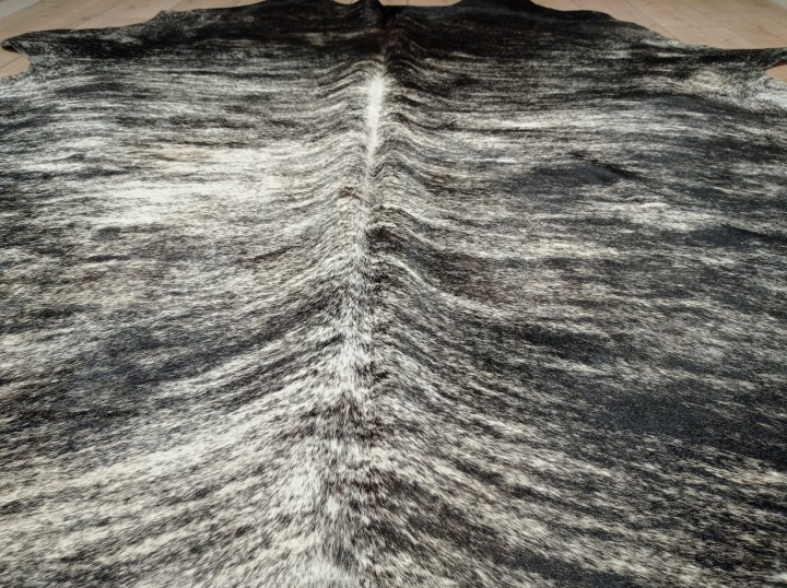 Zbliżenie na ogromną czarno-beżową skórę bydlęcą XXL zajmująca dużą powierzchnię salonu - dekoracyjneskory.pl