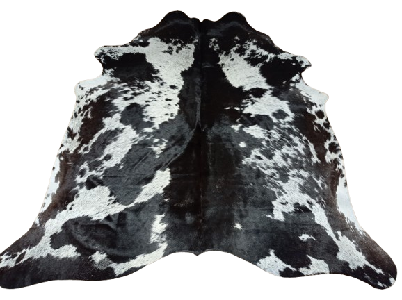 Czarno-brązowo-biała skóra bydlęca w cętki rozłożona na jasnej podłodze - dekoracyjneskory.pl