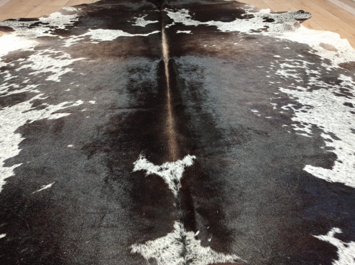 Ogromna łaciata skóra bydlęca XXL zajmująca dużą powierzchnię salonu -  widok  z bliska - dekoracyjneskory.pl