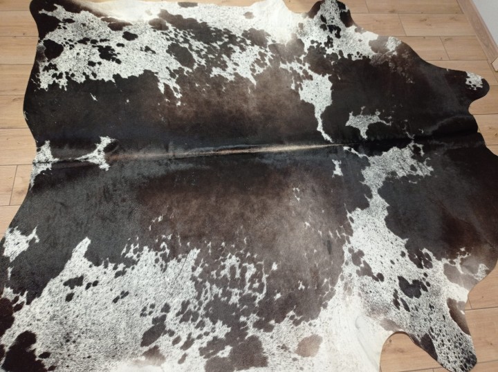 Ogromna czarno-brązowo-biała skóra bydlęca 235x225 cm rozłożona w dużym salonie - wzór łaciata XXL - dekoracyjneskory.pl