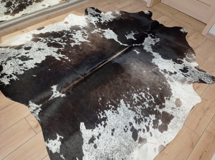 Ogromna czarno-brązowo-biała skóra bydlęca 235x225 cm rozłożona w dużym salonie - wzór łaciata XXL - dekoracyjneskory.pl