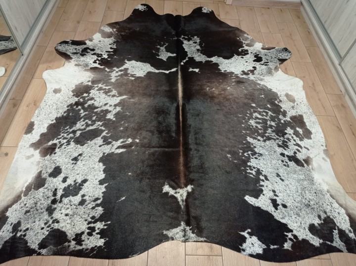 Ogromna czarno-brązowo-biała skóra bydlęca 235x225 cm rozłożona w dużym salonie - wzór łaciata XXL - dekoracyjneskory.pl