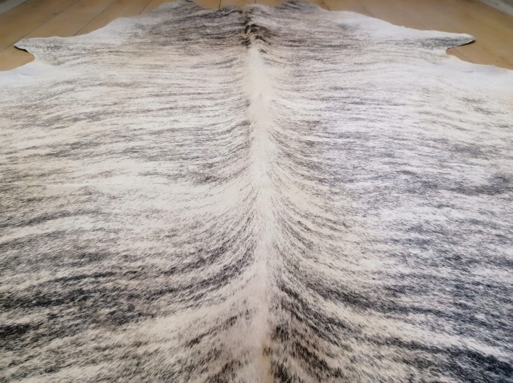 Naturalna skóra bydlęca 220x200 cm rozłożona w dużym salonie -zbliżenie na lśniącą sierść -  dekoracyjneskory.pl