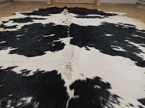 Zbliżenie na naturalną skórę bydlęcą 210x175 cm rozłożoną w dużym salonie - ŁACIATA - dekoracyjneskory.pl