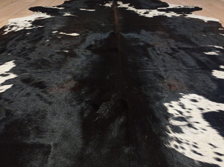 Zbliżenie na naturalną skórę bydlęcą 220x185 cm rozłożoną w dużym salonie - ŁACIATA - dekoracyjneskory.pl