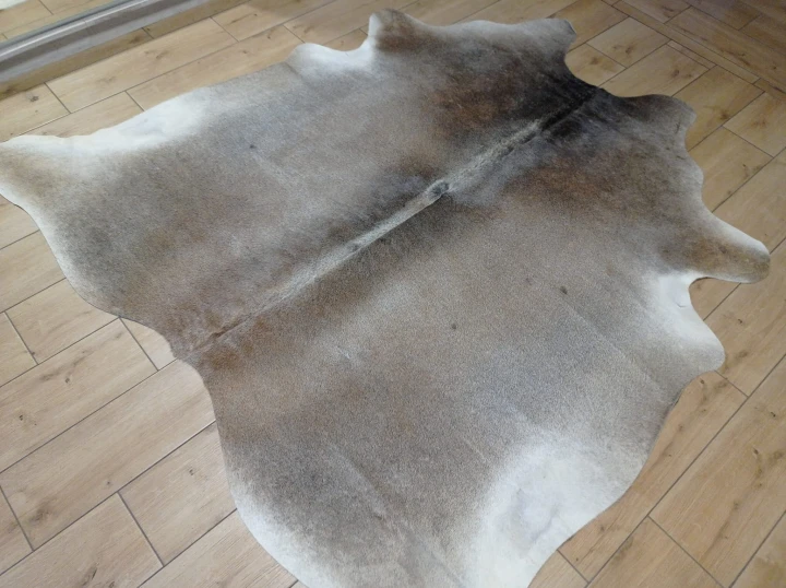 Naturalna skóra bydlęca 185x190 cm rozłożona w dużym salonie  - dekoracyjneskory.pl