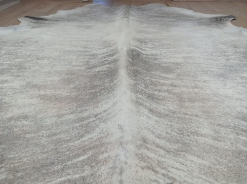 Naturalna skóra bydlęca 210x190 cm rozłożona w dużym salonie  - zbliżenie na lśniący włos - dekoracyjneskory.pl