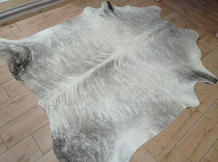 Naturalna skóra bydlęca 210x190 cm rozłożona w dużym salonie  - dekoracyjneskory.pl