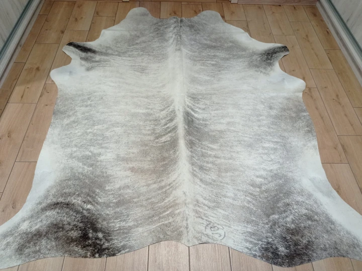 Naturalna skóra bydlęca 210x190 cm rozłożona w dużym salonie  - dekoracyjneskory.pl