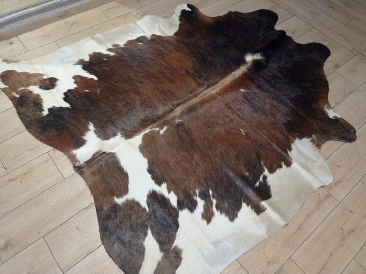 Naturalna skóra bydlęca 200x190 cm rozłożona w dużym salonie  - dekoracyjneskory.pl