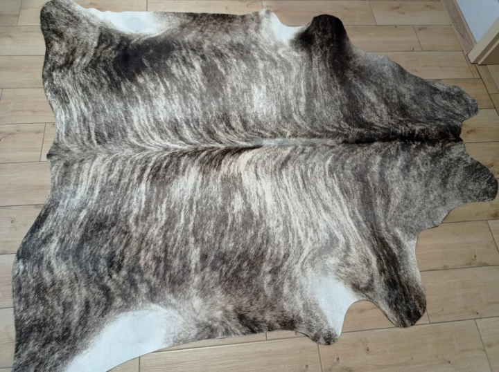 Naturalna skóra bydlęca 195x190 cm rozłożona w dużym salonie  - dekoracyjneskory.pl