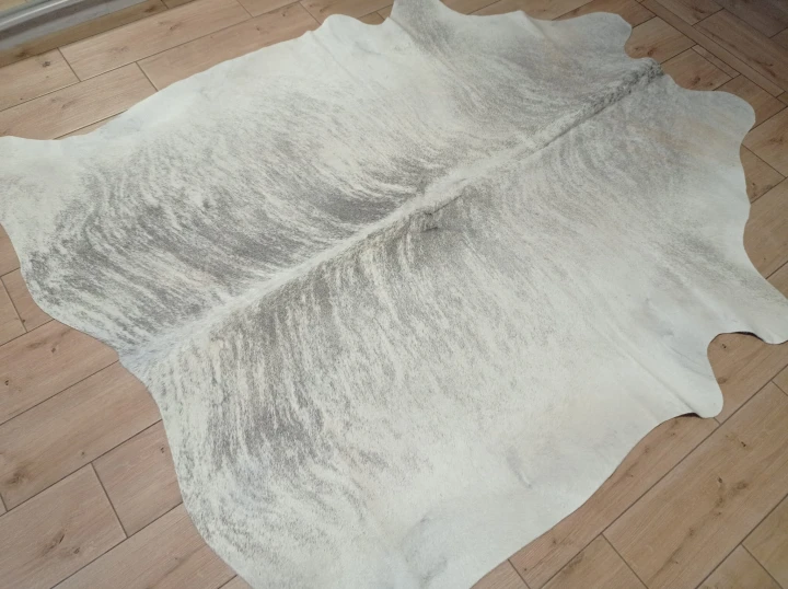 Naturalna skóra bydlęca 205x185 cm rozłożona w dużym salonie  - dekoracyjneskory.pl