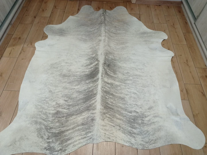 Naturalna skóra bydlęca 205x185 cm rozłożona w dużym salonie  - dekoracyjneskory.pl