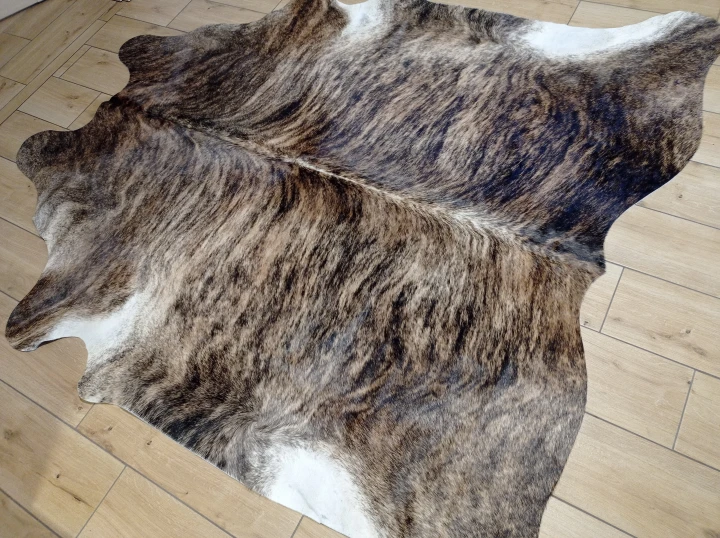 Naturalna skóra bydlęca 195x190 cm rozłożona w dużym salonie  - dekoracyjneskory.pl