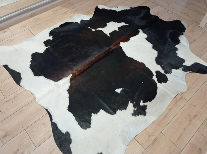 Naturalna skóra bydlęca ŁACIATA 205x190 cm rozłożona w dużym salonie  - dekoracyjneskory.pl
