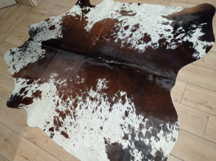 Naturalna skóra bydlęca ŁACIATA 195x195 cm rozłożona w dużym salonie  - dekoracyjneskory.pl