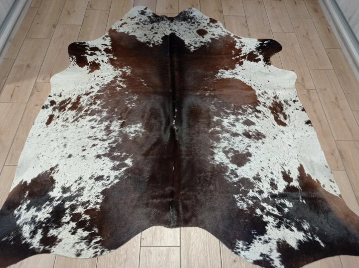 Naturalna skóra bydlęca ŁACIATA 195x195 cm rozłożona w dużym salonie  - dekoracyjneskory.pl