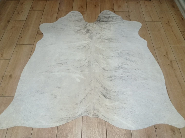 Naturalna skóra bydlęca KREMOWO-SZARA 150x148 cm rozłożona w dużym salonie  - dekoracyjneskory.pl