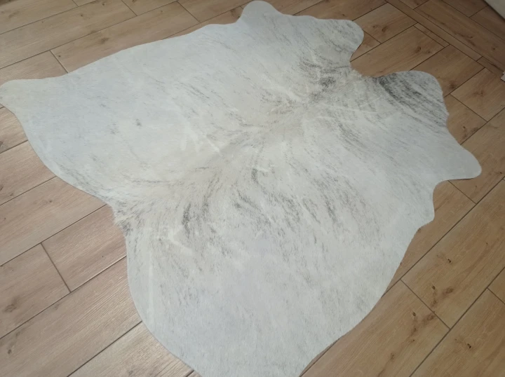 Naturalna skóra bydlęca KREMOWO-SZARA 150x148 cm rozłożona w dużym salonie  - dekoracyjneskory.pl