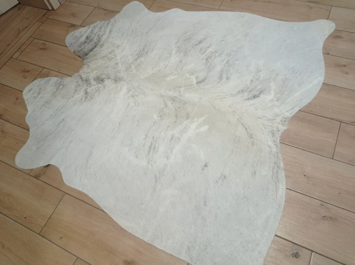 Naturalna skóra bydlęca KREMOWO-SZARA 150x148 cm rozłożona w dużym salonie  - dekoracyjneskory.pl