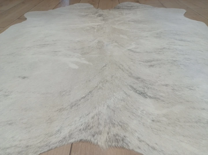 Naturalna skóra bydlęca KREMOWO-SZARA 150x148 cm rozłożona w dużym salonie  - zbliżenie na lśniący włos - dekoracyjneskory.pl
