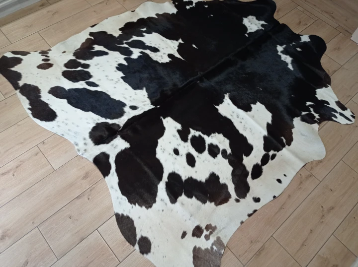 Naturalna skóra bydlęca ŁACIATA 185x185 cm rozłożona w dużym salonie  - dekoracyjneskory.pl