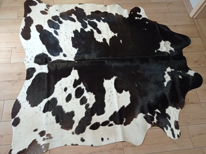 Naturalna skóra bydlęca ŁACIATA 185x185 cm rozłożona w dużym salonie  - dekoracyjneskory.pl