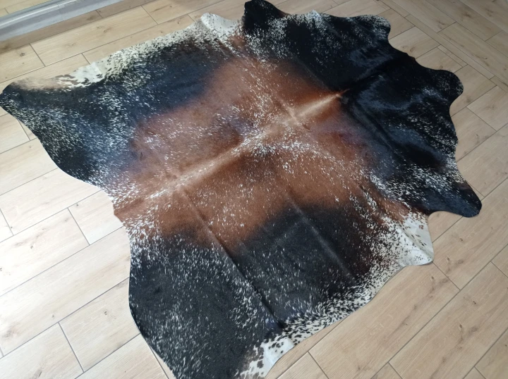 Naturalna skóra bydlęca Brązowo-czarna 195x175 cm rozłożona w dużym salonie  - dekoracyjneskory.pl
