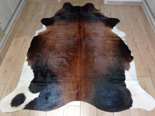 Naturalna skóra bydlęca BRĄZOWO-CZARNA 255x180 cm rozłożona w dużym salonie  - dekoracyjneskory.pl
