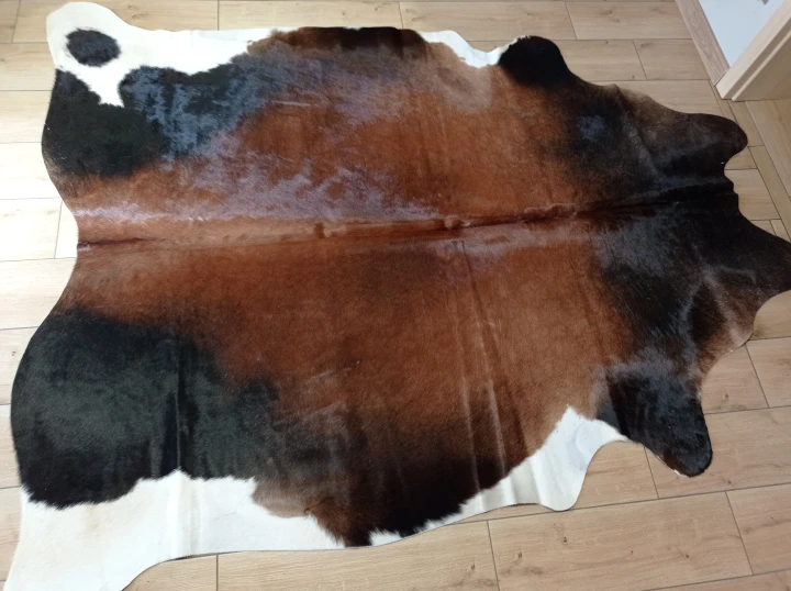 Naturalna skóra bydlęca BRĄZOWO-CZARNA 255x180 cm rozłożona w dużym salonie  - dekoracyjneskory.pl