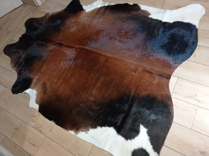Naturalna skóra bydlęca BRĄZOWO-CZARNA 255x180 cm rozłożona w dużym salonie  - dekoracyjneskory.pl