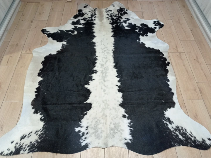 Naturalna skóra bydlęca CZARNO-KREMOWA 210x175 cm rozłożona w dużym salonie  - dekoracyjneskory.pl
