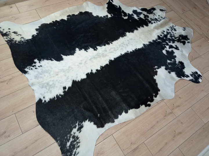 Naturalna skóra bydlęca CZARNO-KREMOWA 210x175 cm rozłożona w dużym salonie  - dekoracyjneskory.pl