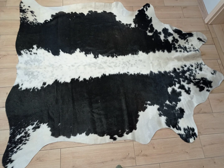 Naturalna skóra bydlęca CZARNO-KREMOWA 210x175 cm rozłożona w dużym salonie  - dekoracyjneskory.pl