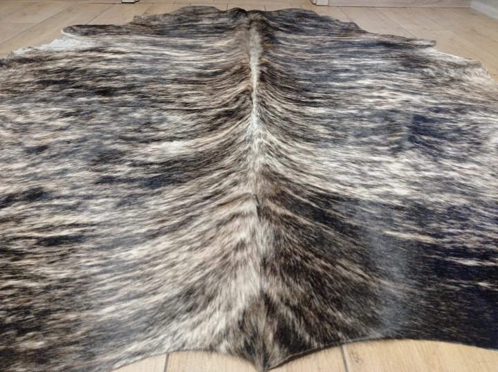 Naturalna skóra bydlęca 180x175 cm rozłożona w dużym salonie  - zbliżenie na lśniący włos - dekoracyjneskory.pl