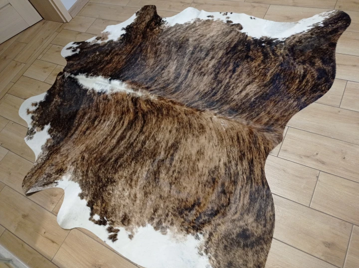 Naturalna skóra bydlęca BRĄZOWO-BIAŁA 200x200 cm rozłożona w dużym salonie  - dekoracyjneskory.pl