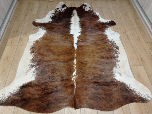 Naturalna skóra bydlęca BRĄZOWO-BIAŁA 210x190 cm rozłożona w dużym salonie  - dekoracyjneskory.pl