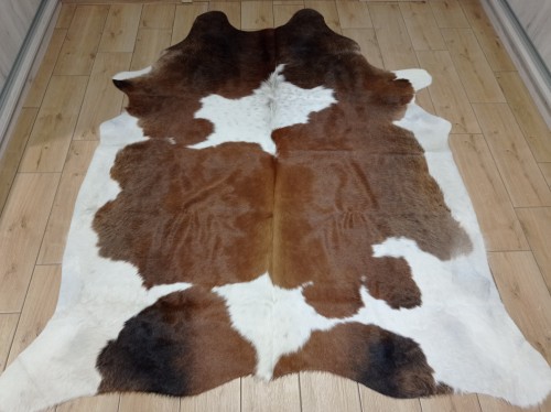 Naturalna skóra bydlęca BRĄZOWO-BIAŁA 205x180 cm rozłożona w dużym salonie  - dekoracyjneskory.pl