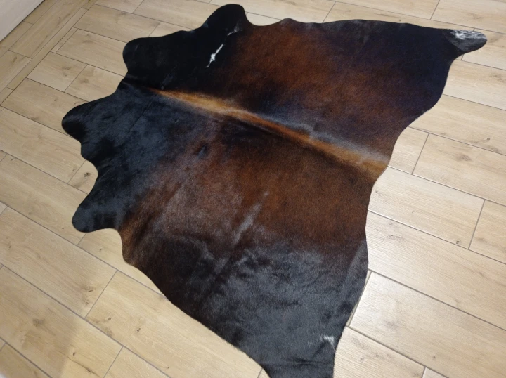 Naturalna skóra bydlęca BRĄZOWO-CZARNA 145x155 cm rozłożona w dużym salonie  - dekoracyjneskory.pl