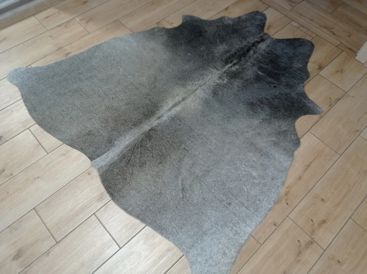 Naturalna skóra bydlęca CIEMNOSZARA 152x152 cm rozłożona w dużym salonie  - dekoracyjneskory.pl