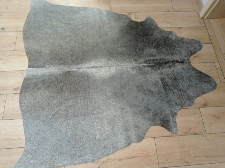 Naturalna skóra bydlęca CIEMNOSZARA 152x152 cm rozłożona w dużym salonie  - dekoracyjneskory.pl
