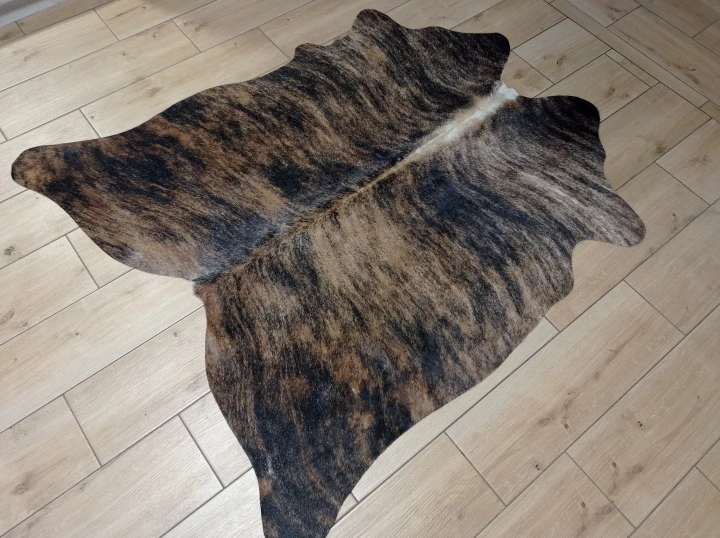Naturalna skóra bydlęca TYGRYS BRĄZOWO-RUDY 140x125 cm rozłożona w dużym salonie  - dekoracyjneskory.pl