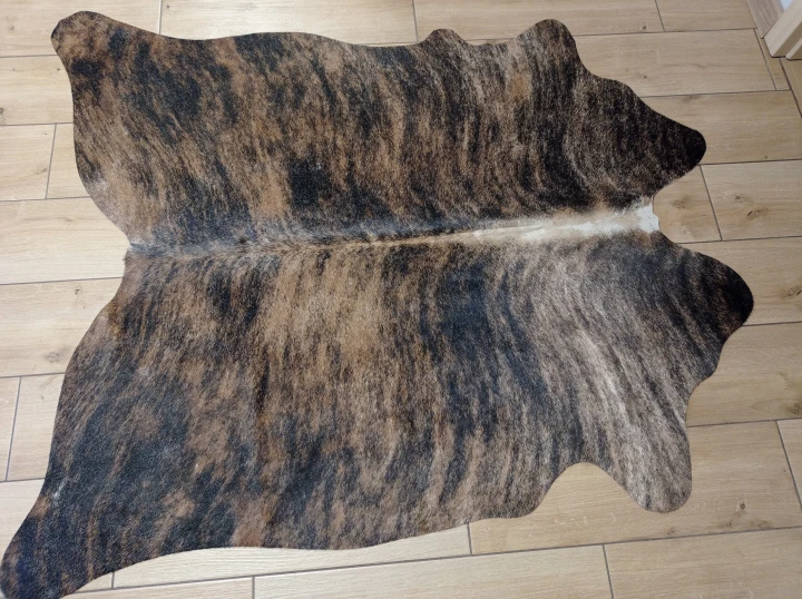 Naturalna skóra bydlęca TYGRYS BRĄZOWO-RUDY 140x125 cm rozłożona w dużym salonie  - dekoracyjneskory.pl
