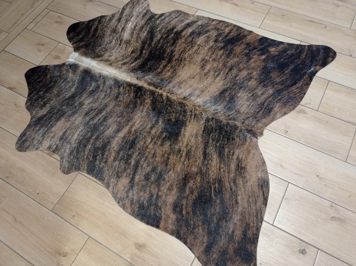 Naturalna skóra bydlęca TYGRYS BRĄZOWO-RUDY 140x125 cm rozłożona w dużym salonie  - dekoracyjneskory.pl