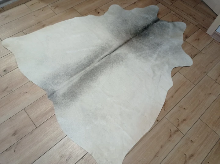 Naturalna skóra bydlęca SZARA 165x155 cm rozłożona w dużym salonie  - dekoracyjneskory.pl