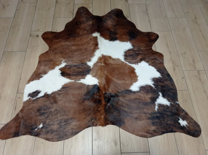 Naturalna skóra bydlęca ŁACIATY TRICOLOR 125x135 cm rozłożona w dużym salonie  - dekoracyjneskory.pl