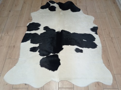 Naturalna skóra bydlęca ŁACIATA CZARNO-KREMOWA 170x140 cm rozłożona w dużym salonie  - dekoracyjneskory.pl